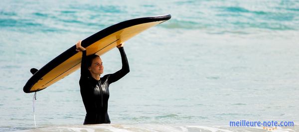 une femme porte son surf