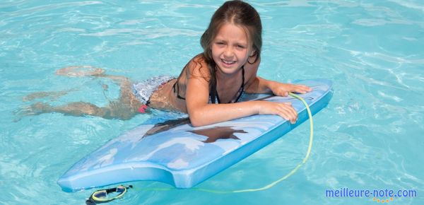 Une petite fille dans la piscine avec un bodyboard