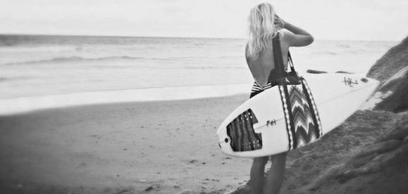 Une femme qui port une housse de planche de surf
