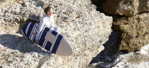 Une femme qui tient une housse de planche de surf