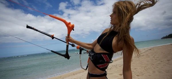 Une femme avec une barre de kitesurf de marque Cabrinha