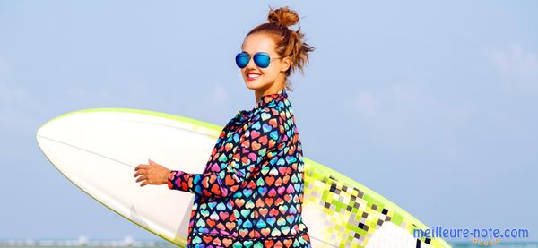 une femme sourit avec une planche de surf