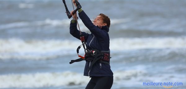 Une femme qui met un harnais de kitesurf