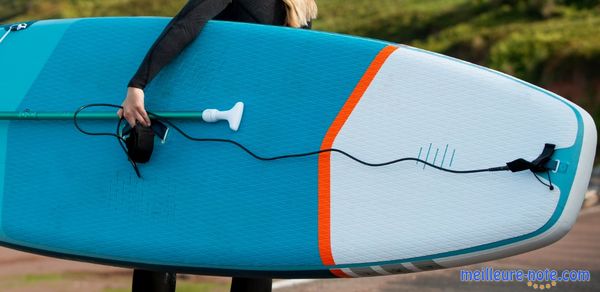 Une fille qui tient une planche de surf et un leash