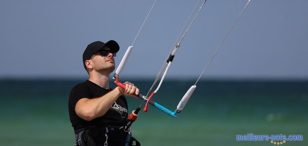 Un homme qui tient une barre de kitesurf