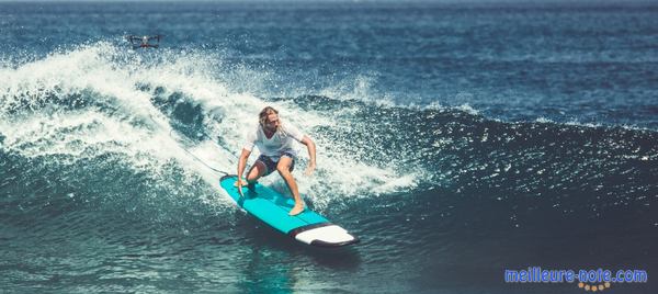 un homme cheveux long sur une vague