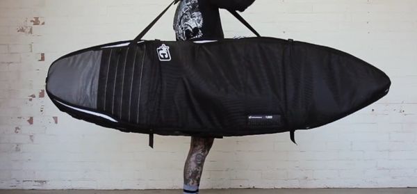 Un homme avec une housse de planche de surf
