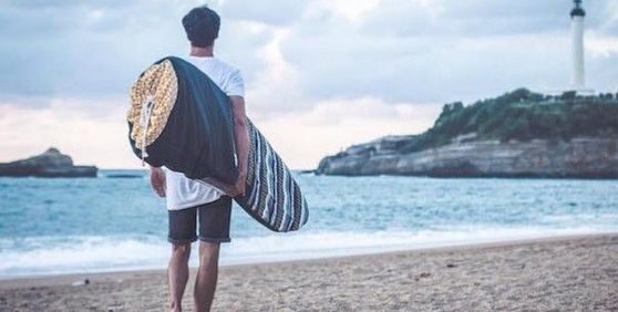 Un homme avec une housse de planche de surf