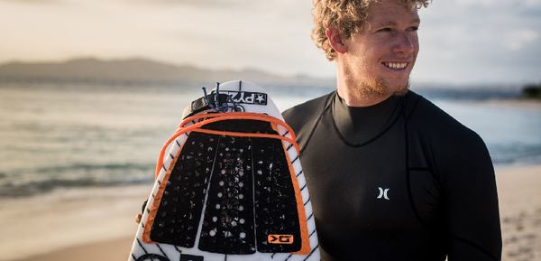 Un homme qui tient une planche de surf avec un pad de surf