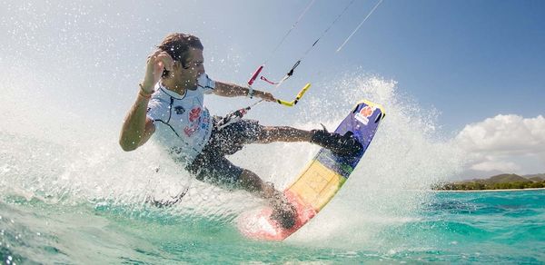 Un homme avec une planche de kitesurf de marque Cabrinha