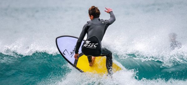 Un surfeur avec une planche de surf de marque Zeus