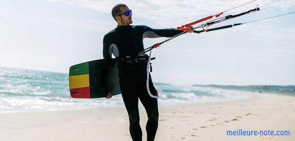 Un homme qui tient son planche de kitesurf