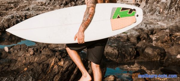 Un homme avec une planche de surf et un pad de surf