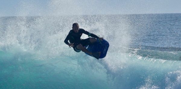 Un surfeur avec un bodyboard de marque Sniper