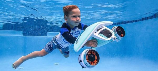un petit enfant utilise le scooter sous marin