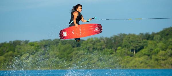 une femme vole avec son wakeboard