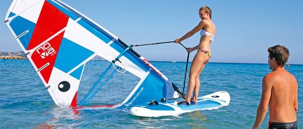 une femme qui est sur une planche de windsurf