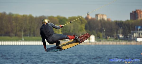 un homme fait un saut avec son wakeboard