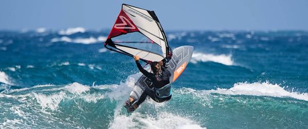 un windsurf à voile sur une vague