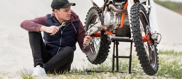 un homme répare un moto 