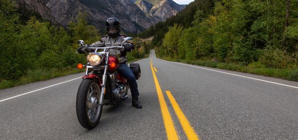 un homme avec sa moto sur la route