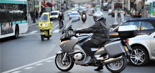 un homme avec sa moto dans une ville