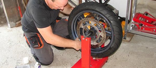 un homme répare la roue avant