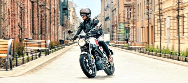 un homme avec sa moto dans une ville