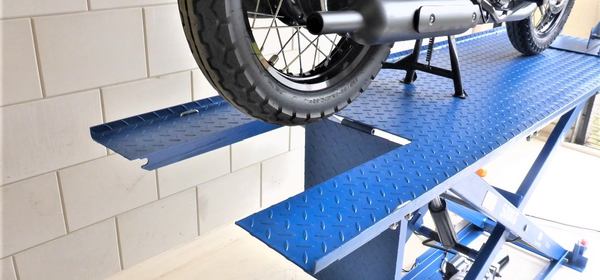 une moto sur une table élévatrice bleue