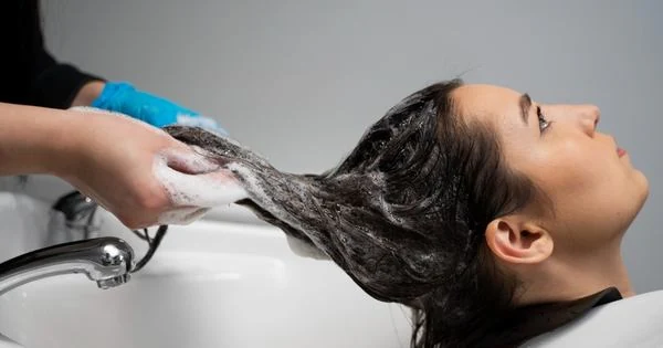 une femme lave le cheveux