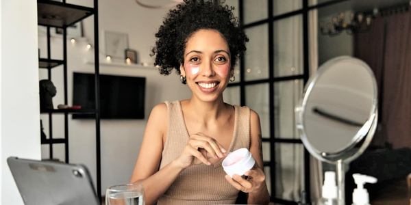 une femme utilise la crème pour la peau dans sa chambre