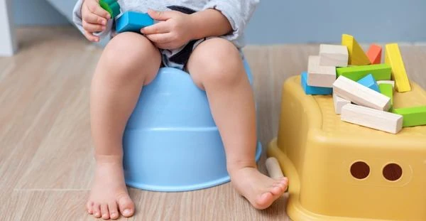 un bebe sur un pot bleu