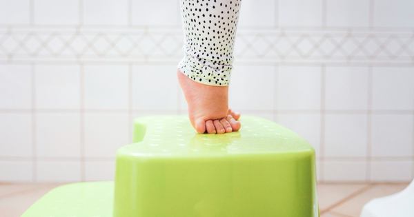 deux pieds d'un petit bébé sur un marche pied