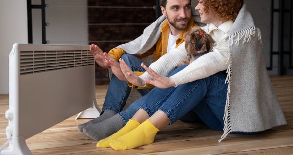 un couple près d'un convecteur électrique