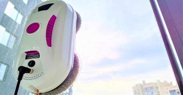 un robot lave vitre rose et blanc